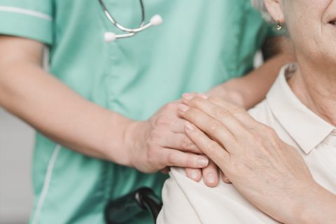 senior-woman-patient-touching-female-nurse-hand-shoulder